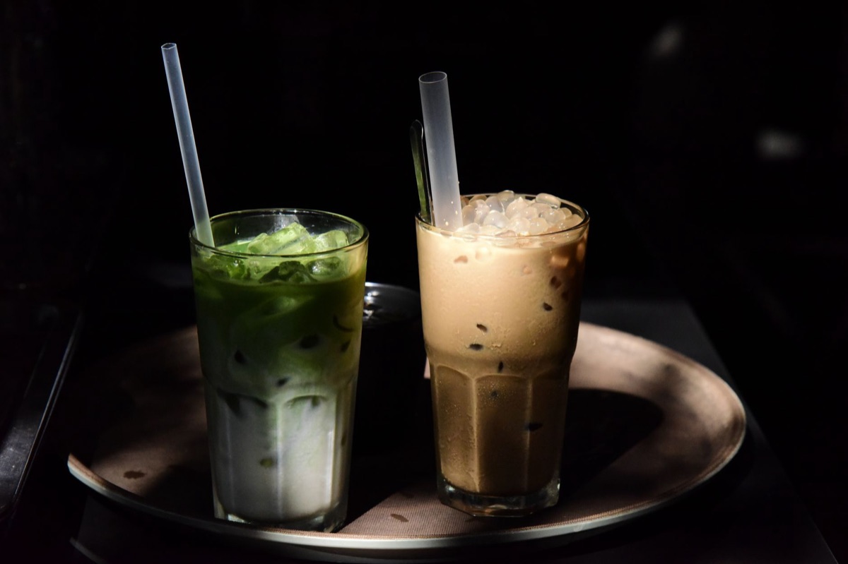 A refreshing iced matcha latte in a clear glass on a wooden table
