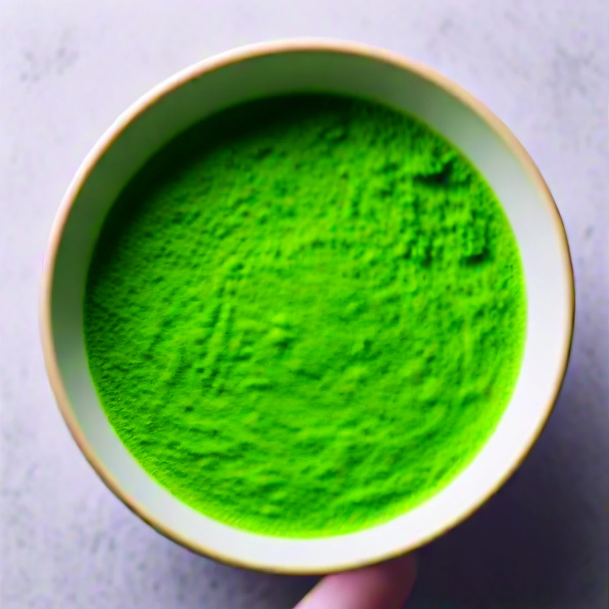 茶碗にふるい入れられる鮮やかな抹茶の粉末