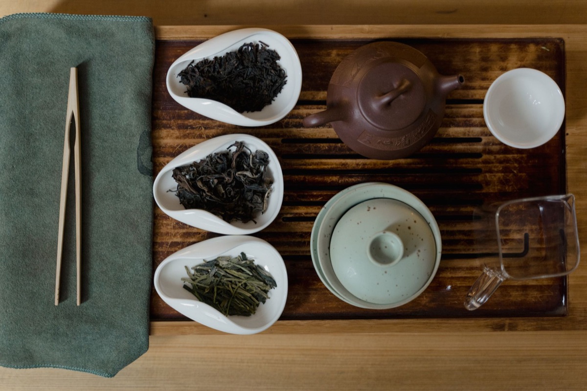 Feuilles de thé Pu-erh séchées sur une table en bois sombre.