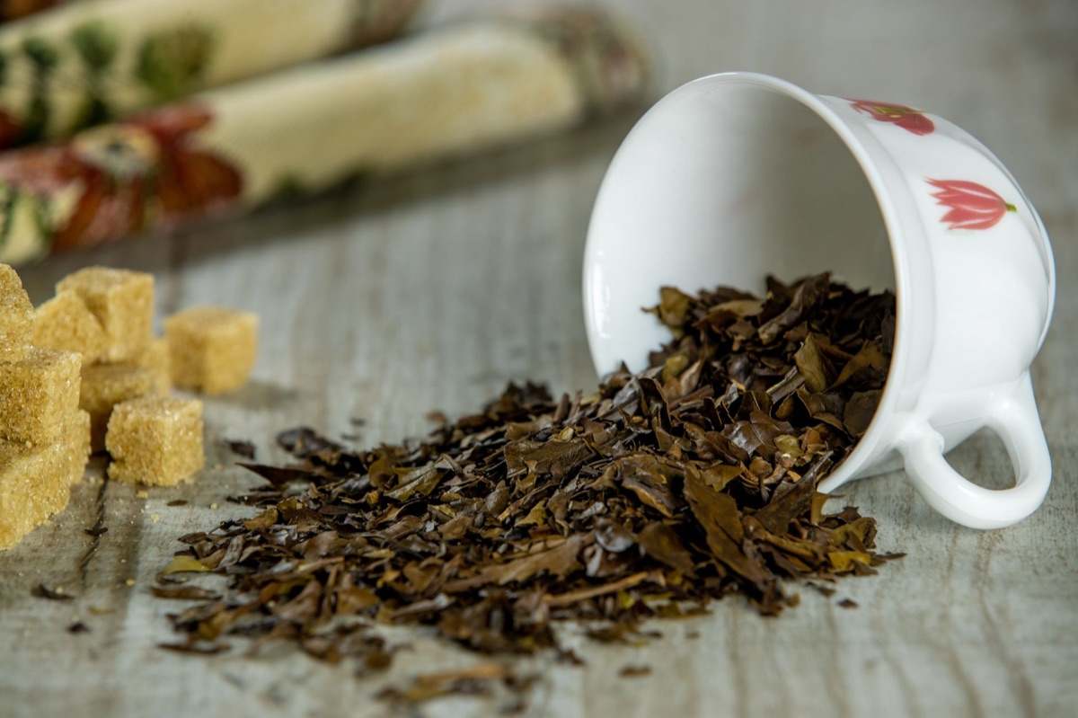 Foglie di tè Pu-erh essiccate su un tavolo di legno scuro.