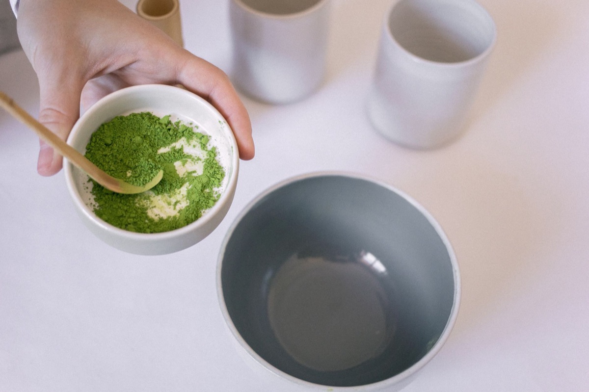 Different grades of vibrant green matcha powder displayed in small ceramic bowls