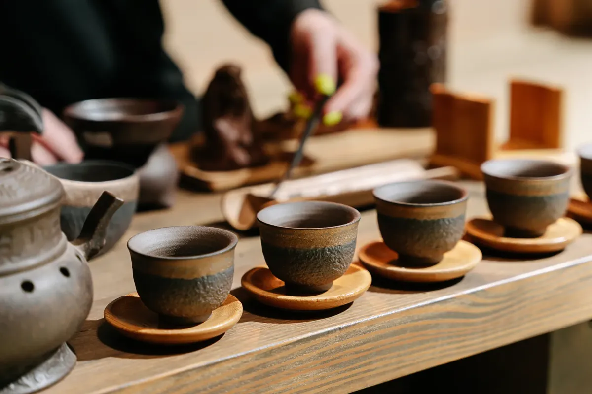 A serene tea ceremony setup with rustic ceramic cups on a wooden table, highlighting traditional tea culture.