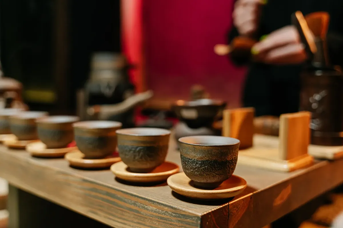 A close-up of earthenware cups arranged on a table for a traditional tea ceremony.