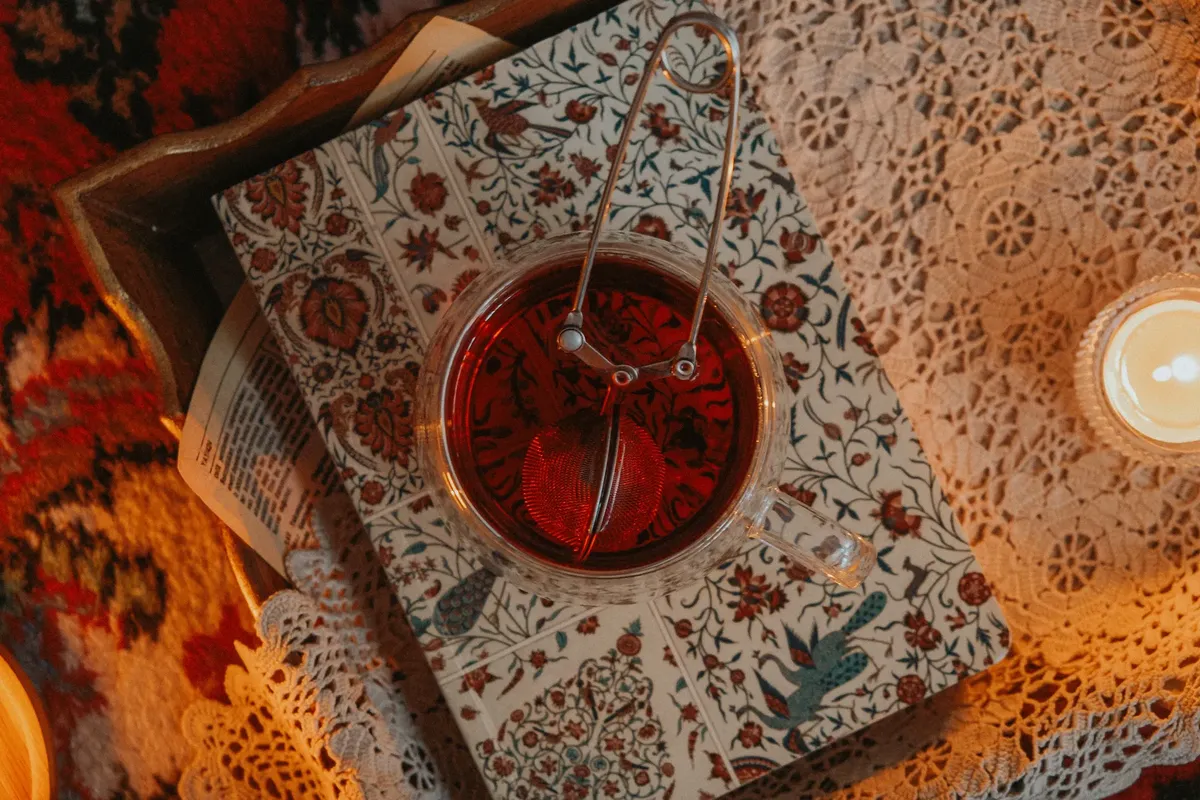 A cozy setting featuring herbal tea, intricate patterns, and warm candlelight ambiance.